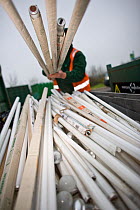Man lifting fluorescent light tubes at a recycling centre, Stroud, Gloucestershire, UK, February 2008.