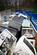 Computer monitors and television sets in containers at a recycling centre, Stroud, Gloucestershire, UK, February 2008.