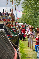 Boats moored up on the Stroudwater navigation with people walking alongside on the bank, Saul Canal Festival, Gloucestershire, UK, July 2008.
