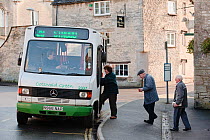 People getting on the rural bus service, Minchinhampton, Gloucestershire, UK, November 2008.