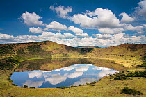 Crater lake with reflections of clouds in the water, Queen Elizabeth National Park, Uganda, January 2009.