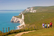 Walkers on the South West Coast Path National Trail near Durdle Door, Dorset, UK, May 2009.