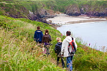 Family walking on the Pembrokeshire Coast Path, Caerfai Bay, Wales, UK, June 2009.