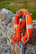 Lifebuoy attached to wall at Caerfai Bay on the Pembrokeshire Coast Path, Wales, UK, June 2009.