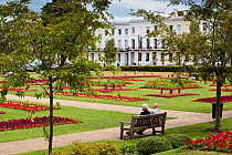 Formal gardens and public green space at Imperial Gardens with elderly couple sat  on bench, Cheltenham, Gloucestershire, UK, July 2011.