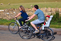 Family cycling in the Cotswolds at Guiting Power, Gloucestershire, UK, August 2011.