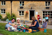 Family having a picnic at Guiting Power in the Cotswolds, Gloucestershire, UK, August 2011. Model released