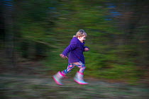 Young girl playing on edge of woodland, Norfolk, January 2012 Model released