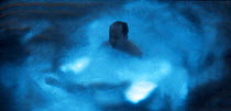 John Ruthven swimming in the Bioluminescence Bay in Vieques, Puerto Rico. Dinoflagellates create the bioluminescense when disturbed. Model released.