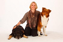 Australian Shepherd, red-tri and mixed breed dog, bitch, 15 years sitting with woman. Model released