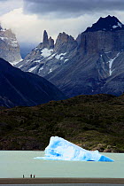 People and an iceberg in Lake Grey with Valle del Frances in the background, Torres del Paine National Park, Patagonia, Chile