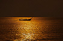 Traditional fishing boat out at sunset, Andaman Sea Thailand