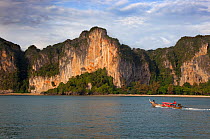 Boat travelling infront of rocky outcrops Railay, Ao Phranang, Thailand