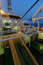 Crew working on deck of the pelagic trawler 'Charisma' at dusk, Shetland Isles, Scotland, UK, October 2011 Model Release available