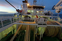 View of deck of the pelagic trawler 'Charisma' at dusk, showing trawler nets and winches, Shetland Isles, Scotland, UK, October 2011