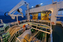 Crew working on deck of the pelagic trawler 'Charisma' in evening, Shetland Isles, Scotland, UK, October 2011