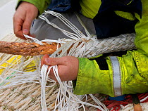 Crew member David Anderson splicing rope on board the pelagic trawler 'Charisma', Shetland Isles, Scotland, UK, October 2011