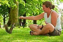 Woman feeding a Grey squirrel (Sciurus carolinensis) in Regent's Park, London, England, UK, April 2011 Model Release Available