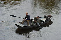 Fisherman in a boat looking for Atlantic salmon (Salmo salar) on the River Tweed, with gillie attending, Coldstream, Berwickshire, Scotland, UK, August 2011