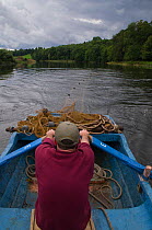 Boatman rowing on the River Tweed rowing trailing nets for a 'run' on the river to catch migratory Atlantic salmon (Salmo salar) and Brown trout (Salmo trutta) for monitoring by The Tweed Foundation s...