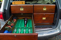 Interior of fishermans car specially fitted out with cabinet to hold fishing equipment with one drawer open displaying wine bottle and glasses, Selkirkshire, Scotland, UK, October 2011
