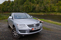 Car of fisherman parked by the River Tweed with fishing rods strapped to outside of the vehicle,  Selkirkshire, Scotland, UK, October 2011