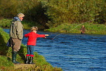 Family fishing from the bank of the River Tweed at Junction Pool, Kelso, Roxburghshire, Scotland, UK, October 2011