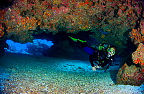 Diver exploring a coral cavern, East End, Grand Cayman, Cayman Islands, British West Indies, Caribbean Sea. Model released
