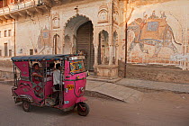 Rickshaw scooter in street with damaged wall painting for Shekhawathi region, Shekhawathi, Rajasthan, India