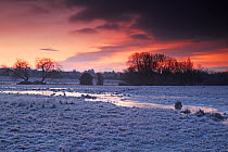Sunrise and frost in Avon Valley ESA and SSSI from Avon Causeway, Hampshire, England, UK, January 2000.