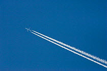 Aeroplane against blue sky and white vapour trail.
