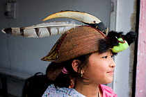 Girl wearing a hat with a hornbill lower mandibel, a raptor feather and civet fur, Tawang, Arunachal Pradesh, India 2008