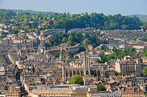 Overview of Bath city showing Bath Abbey, crescents of terraced houses following contours of the hills and shoppers on Stall and Union streets, Somerset, UK, April 2011