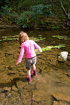 Girl playing in River Onny,experiencing nature by paddling,Shropshire,England,UK, 2011