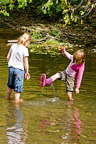 Children playing in River Onny,understanding nature by gathering river stones make oven for pizzas,Shropshire,England, UK 2011