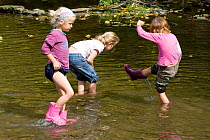 Children playing in River Onny,understanding nature by gathering river stones make oven for pizzas,Shropshire,England, UK 2011