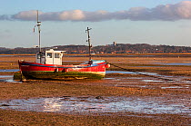 Fishing boat at low tide in Blakeney Harbour, Norfolk January 2012