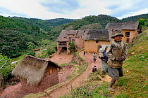 Malagasy village landscape with young boy and other various people in background, Madagascar 2008.