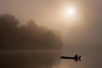 Fishermen on Tisza River, sunrise on a foggy morning, Hungary, June