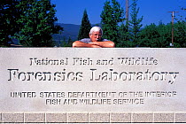 Director, Ken Goddard, leaning on sign for the National Fish and Wildlife Forensics Laboratory, Ashland, Oregon, USA