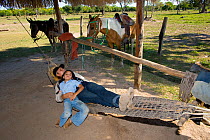 Sra Ternura, wife of Sr Arteaga, owner of Estancia Tacuaral, and her daughter relaxing on a hammock made from the skin of a Black Caiman, Santa Ana del Yacuma, Beni, Bolivia, July 2008