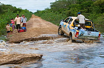 Vehicle crossing ford in flooded road on conservation survey of the Critically endangered Blue throated / Wagler's macaw (Ara glaucogularis) Trinidad, Beni, Bolivia, January 2008