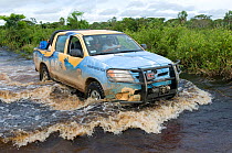 Vehicle crossing ford in flooded road on conservation survey of the Critically endangered Blue throated / Wagler's macaw (Ara glaucogularis) Trinidad, Beni, Bolivia, January 2008
