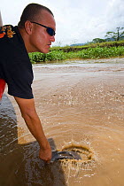 Jason Vargas Aguerro 'Crocodile Man' slapping the water to attract American Crocodile (Crocodylus acutus) to the tourist boat. Carara National Park, Tarcoles, Costa Rica, August 2008.