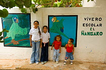 Children standing by the murals of the parrot conservation project, where Yellow-shouldered Amazons are raised. Isla Margarita, Nueva Esparta, Venezuela, 2007.