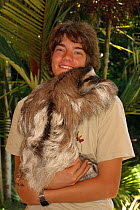 Conservation worker with tame Brown-throated Three Toed sloth (Bradypus variegatus).   Aviarios del Caribe Sloth Sanctuary, Costa Rica, 2008.