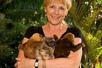 Brown-throated Three Toed Sloth (Bradypus variegatus) and Hoffmann's Two Toed Sloths (Choloepus hoffmanni) babies held by orphanage owner, Judy Avey-Arroyo. Aviarios del Caribe Sloth Refuge, Costa Ric...