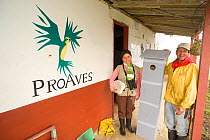 Conservation worker Ana Maria Velasquez and an assistant with artificial nesting boxes for parrots to raise chicks in. Orejiamarillo Nature Park, Jardin, Antioquia, Colombia.
