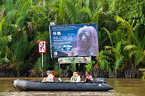 Tourists in zodiac boat at the mouth of the Sekonyer River about to enter Tanjung Puting National Park, on the way to Camp Leakey near Kumai, Kalimantan, Borneo, February 2012.
