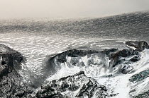 Edge of the Eyjafjallajokull ice cap, partly covered in volcanic ash after the subglacial eruption, Iceland, April 2010